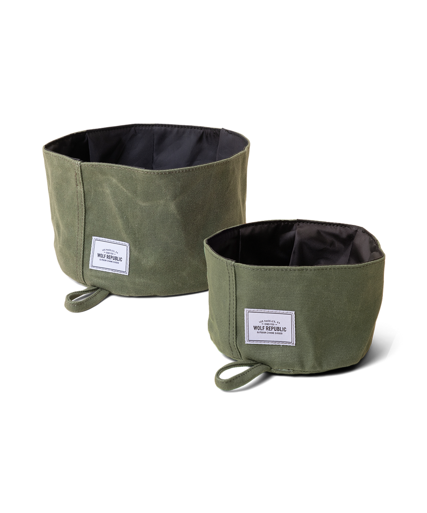 Two collapsible dog bowls made from green waxed canvas sit side by side one is a large size one is a small size