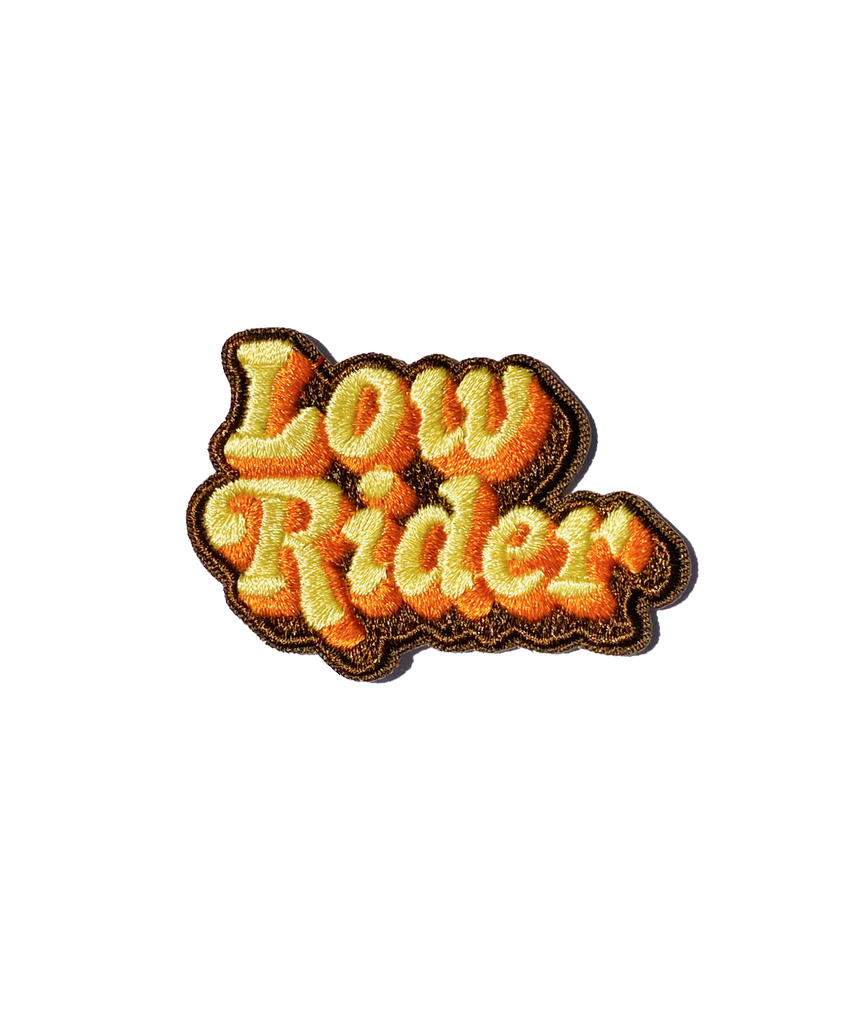 A yellow orange and brown embroidered patch that reads low rider