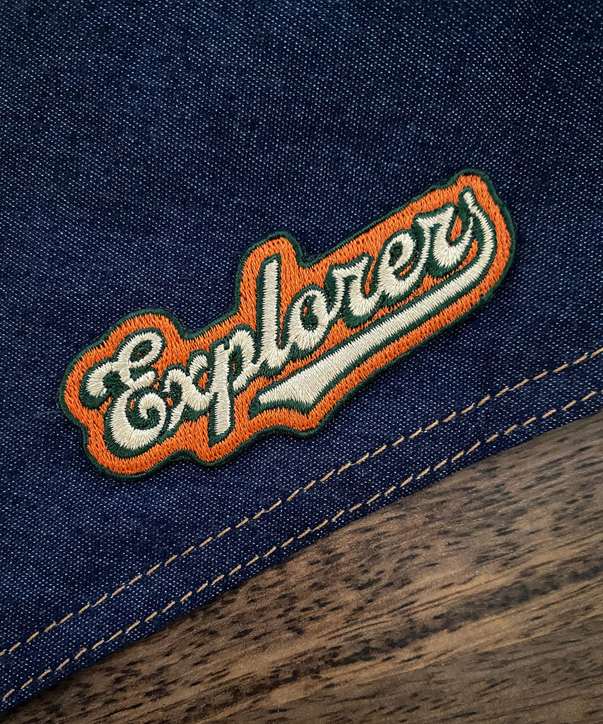 embroidered patch for adventure dogs that reads explorer applied to a denim dog bandana