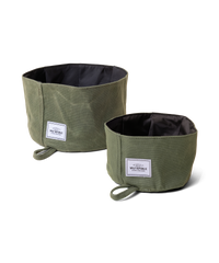 Two collapsible dog bowls made from green waxed canvas sit side by side one is a large size one is a small size