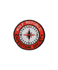 A red and white embroidered patch for dogs in the shape of a circle compass that reads Wolf Republic Expedition Society